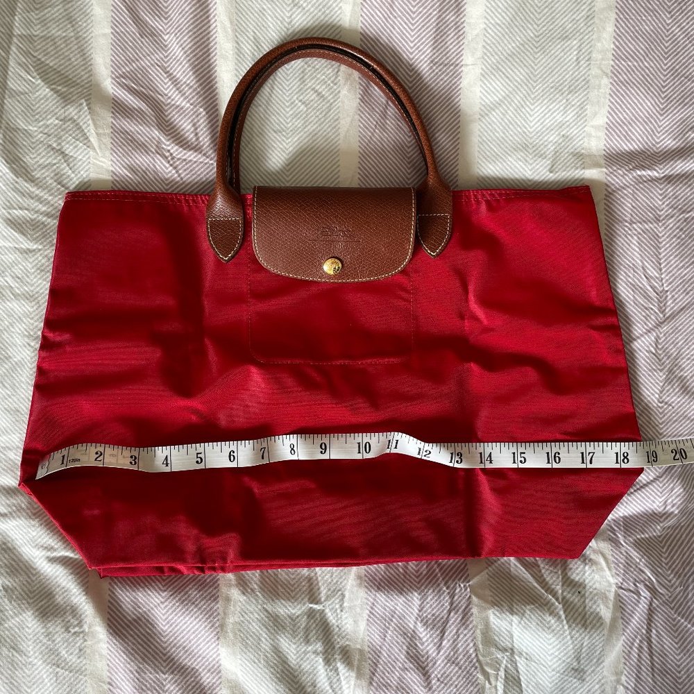 Longchamp Le Pliage red tote bag with brown leather handles
